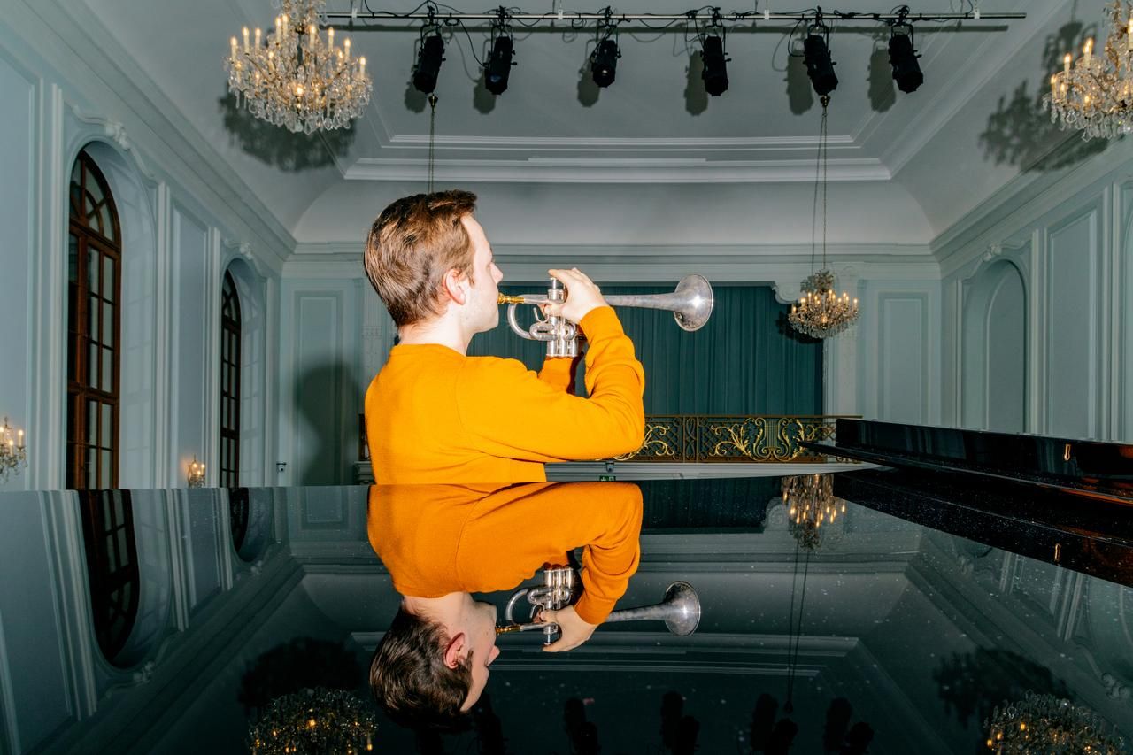 Trompete spielender junger Mann im Grossen Saal der MAB - gespiegelt im Flügel